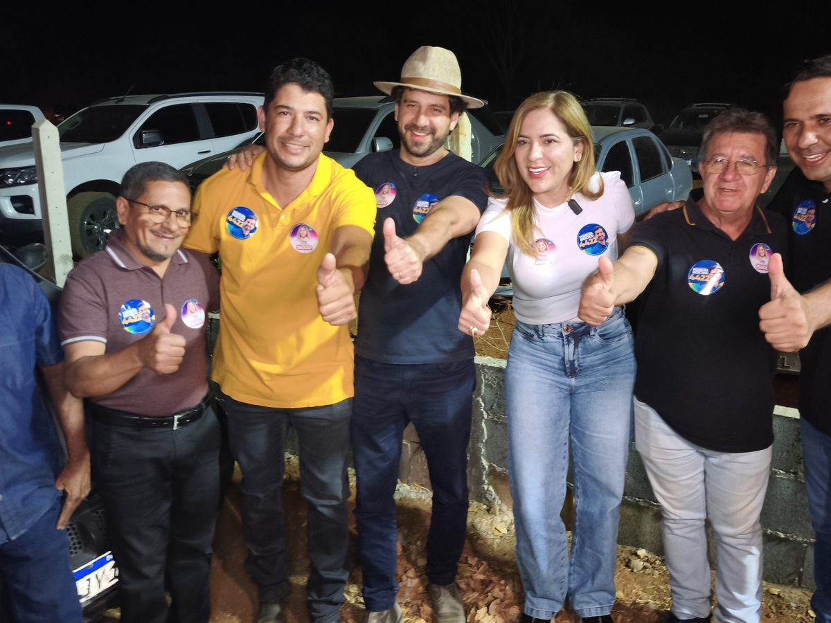 Bete ao lado de apoiadores e lideranças, todos com o polegar erguido, em ato de campanha à noite