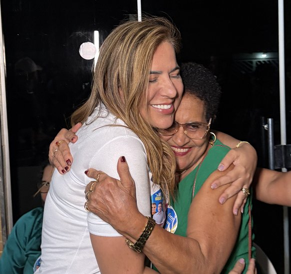 Bete abraçada a uma apoiadora de blusa verde, as duas sorrindo