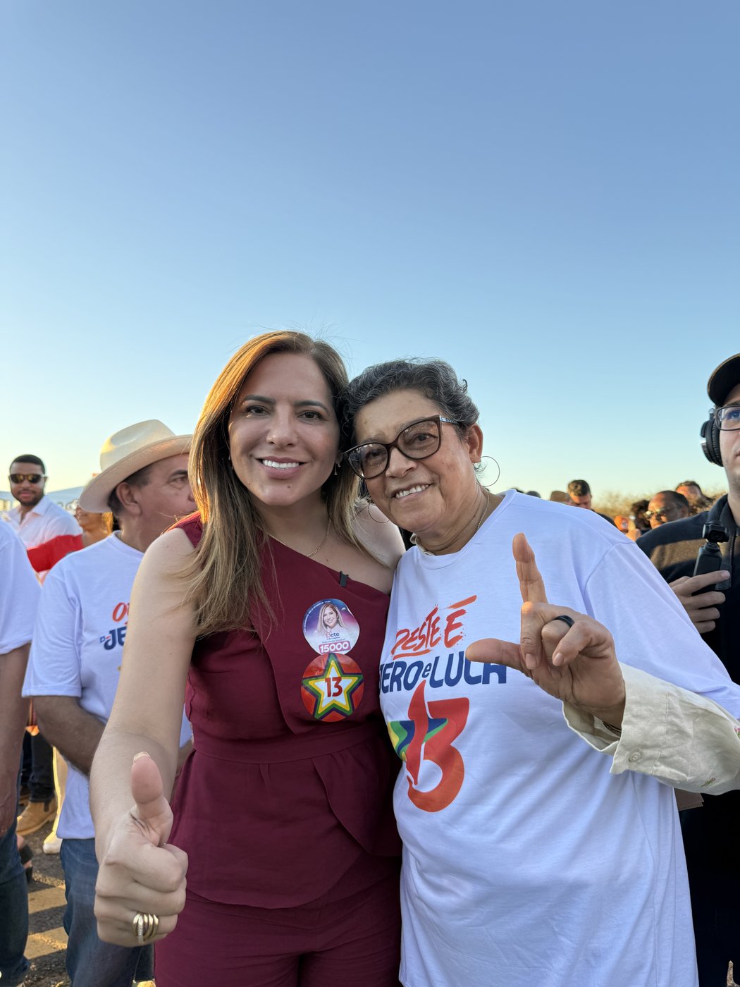 Bete ao lado de uma apoiadora de camiseta branca em ato de campanha ao ar livre